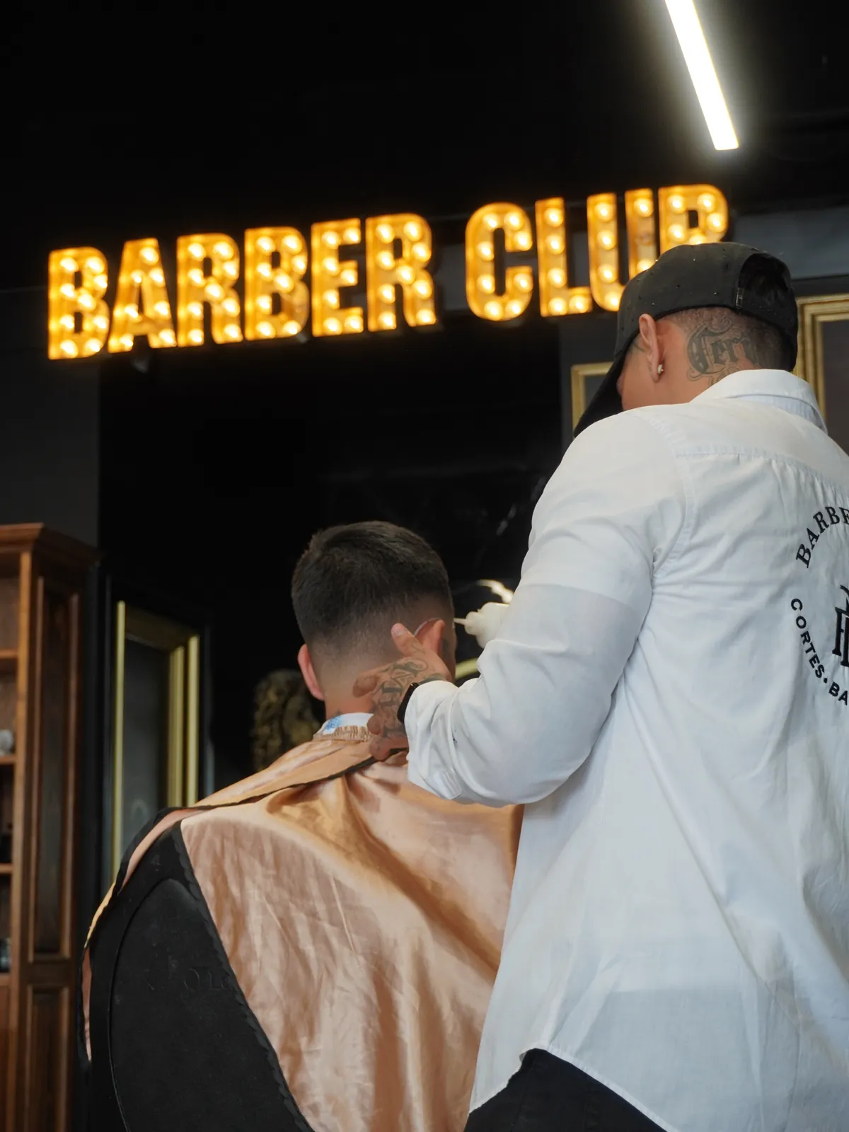 Corte bajo el letrero luminoso Barber Club de MP